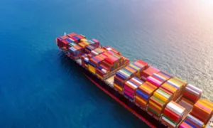 Aerial view of a container ship loaded with colourful containers crossing open sea