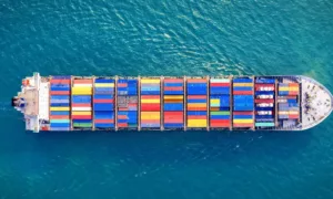Top down view of a container vessel fully loaded with containers sailing at sea